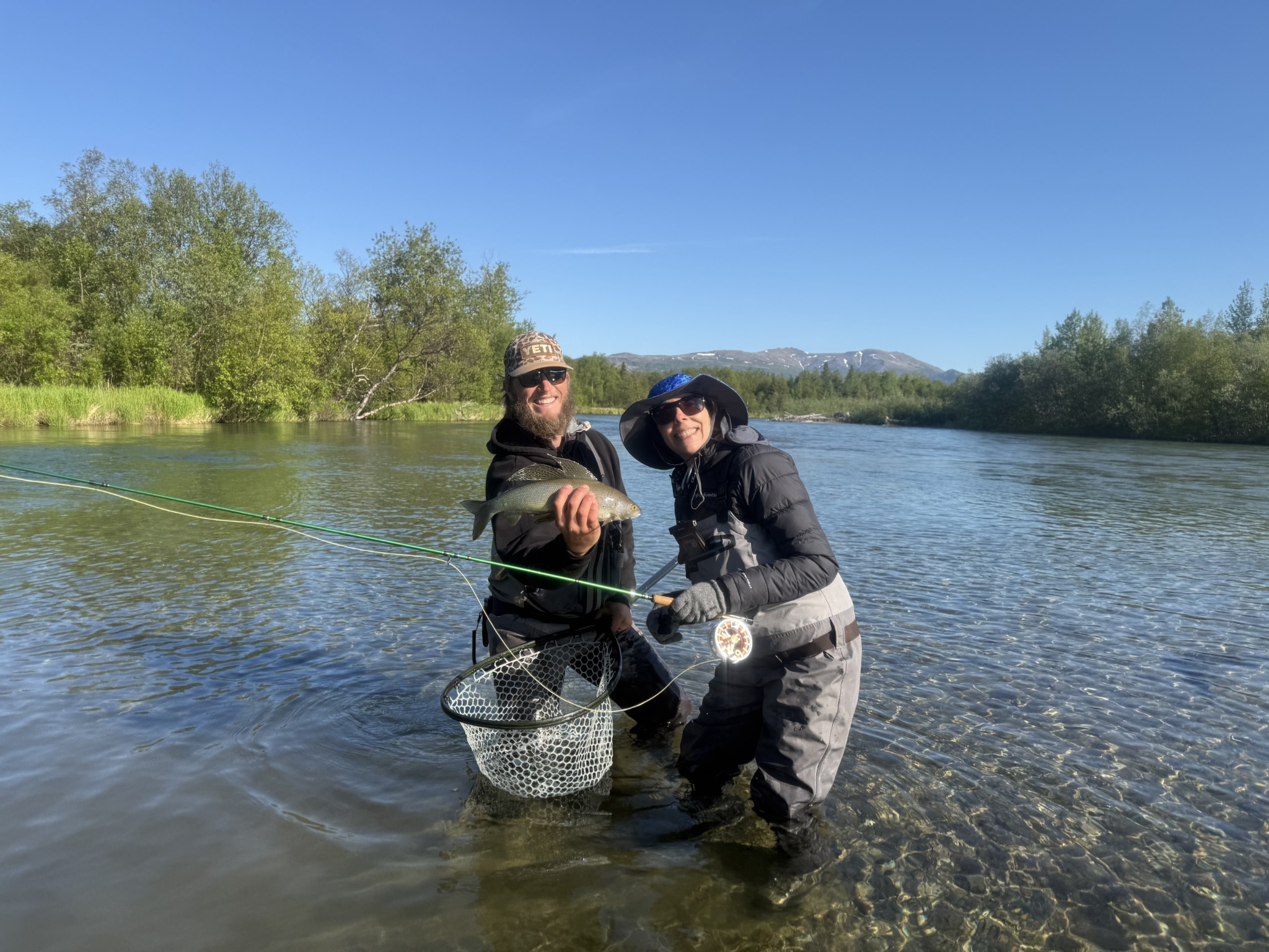 Michelle enjoying a fly-fishing adventure in a scenic river with a fishing guide